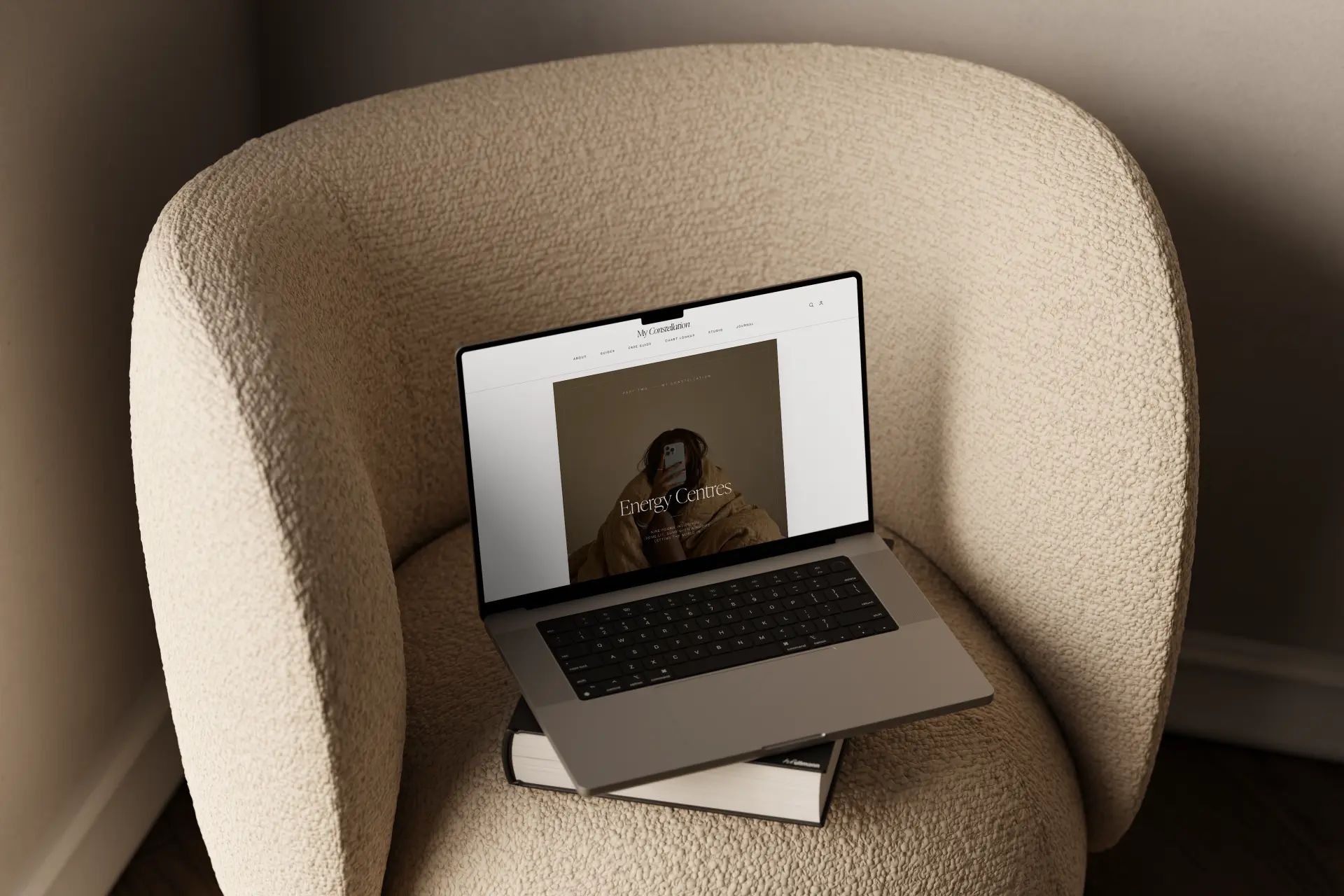 The Human Design Guide on a laptop in a cream boucle armchair, showing the Energy Centres divider