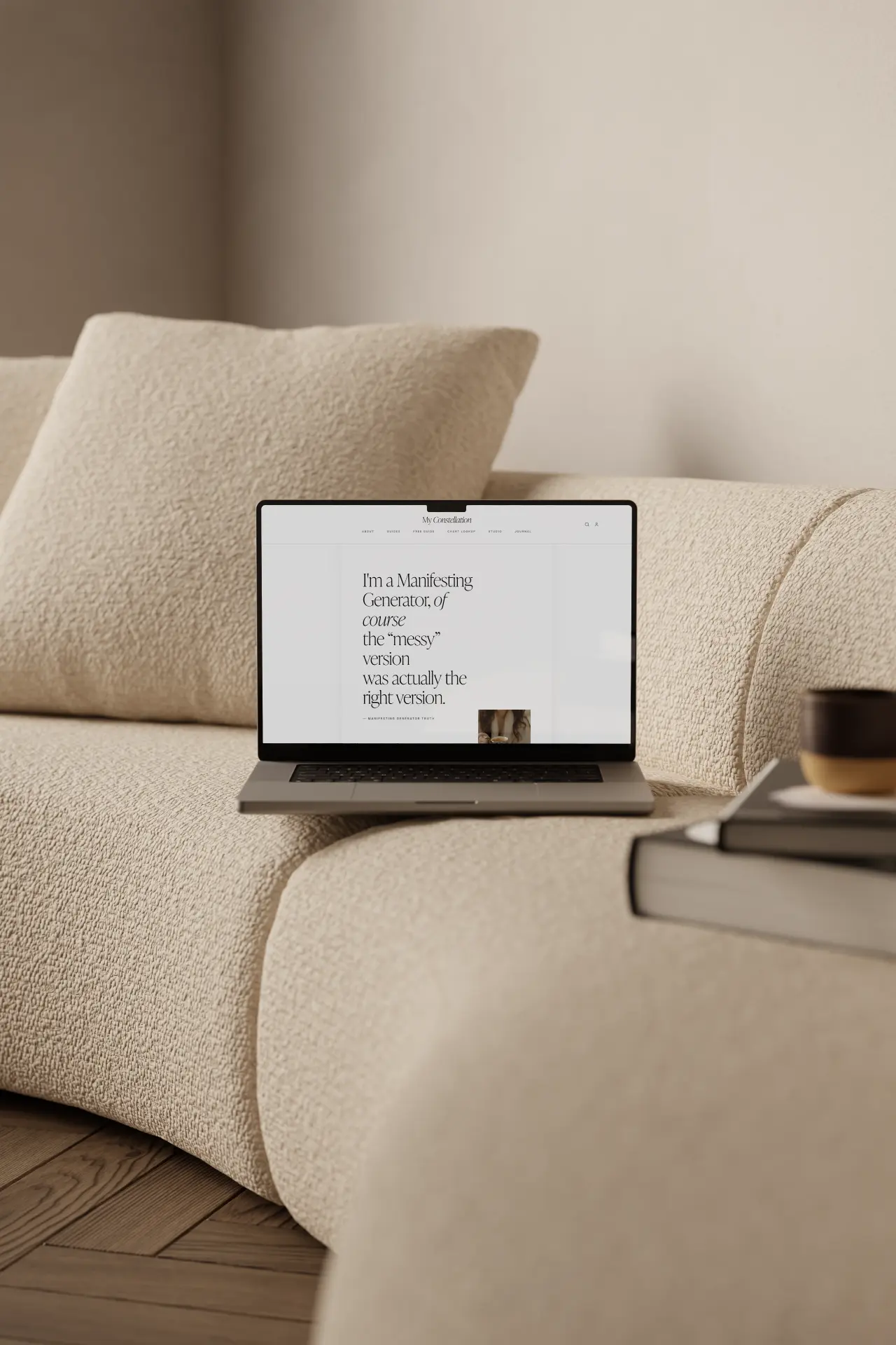 The Human Design Guide on a laptop on a cream sofa, showing a Manifesting Generator quote page
